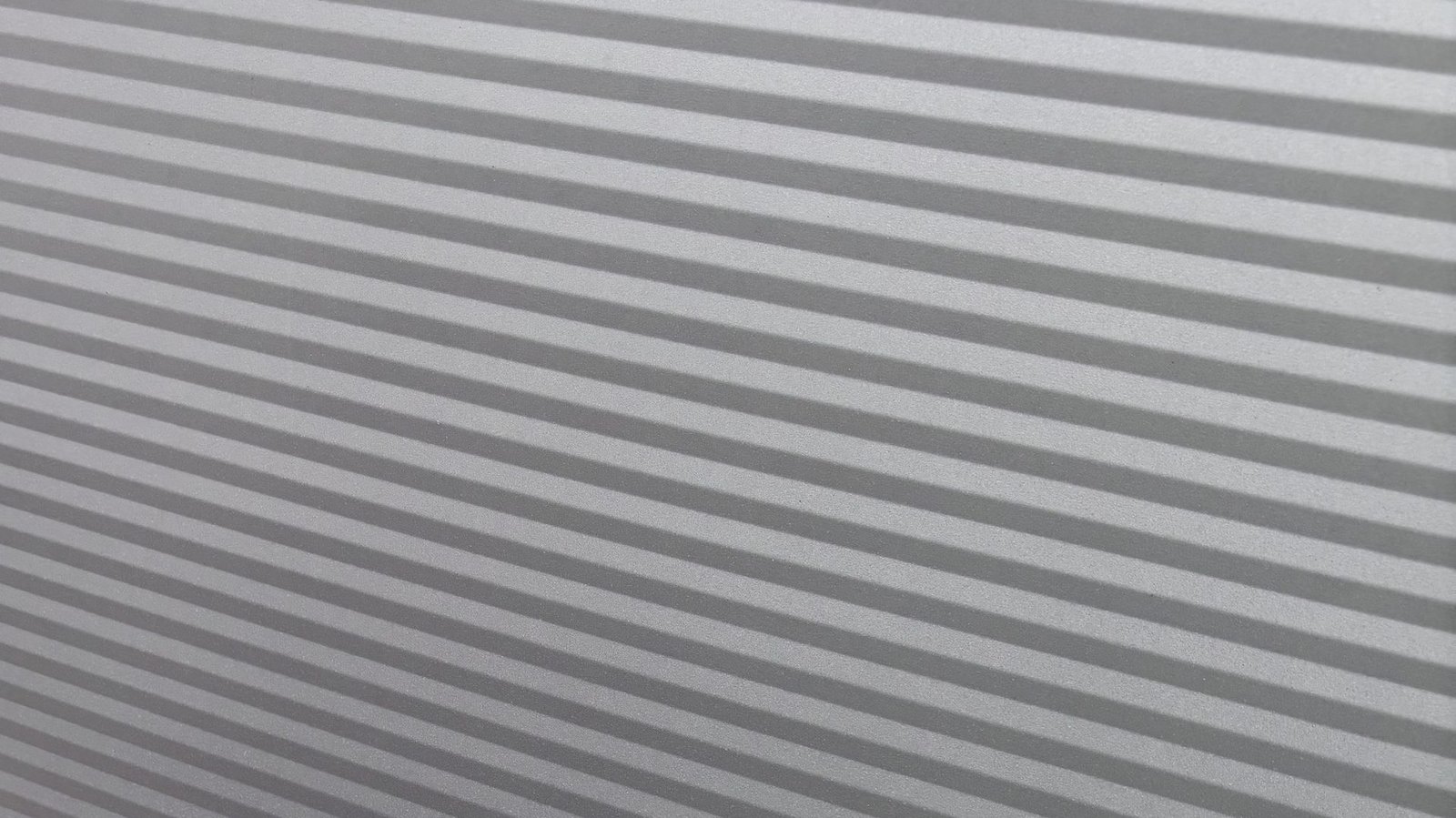 Nahaufnahme einer Metallfassade mit Streiflicht